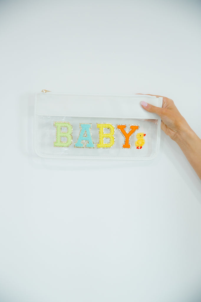 Clear travel bag with "baby" in rainbow letters with a duckling patch