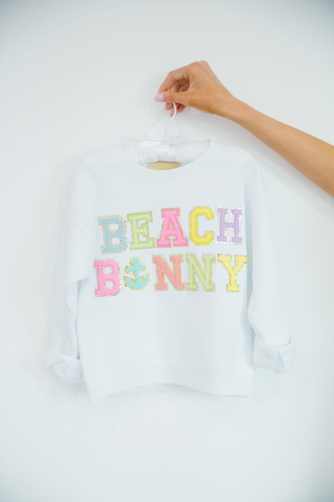 Kids white pullover with "beach bunny" in colorful mini terry lettering and an anchor patch. 