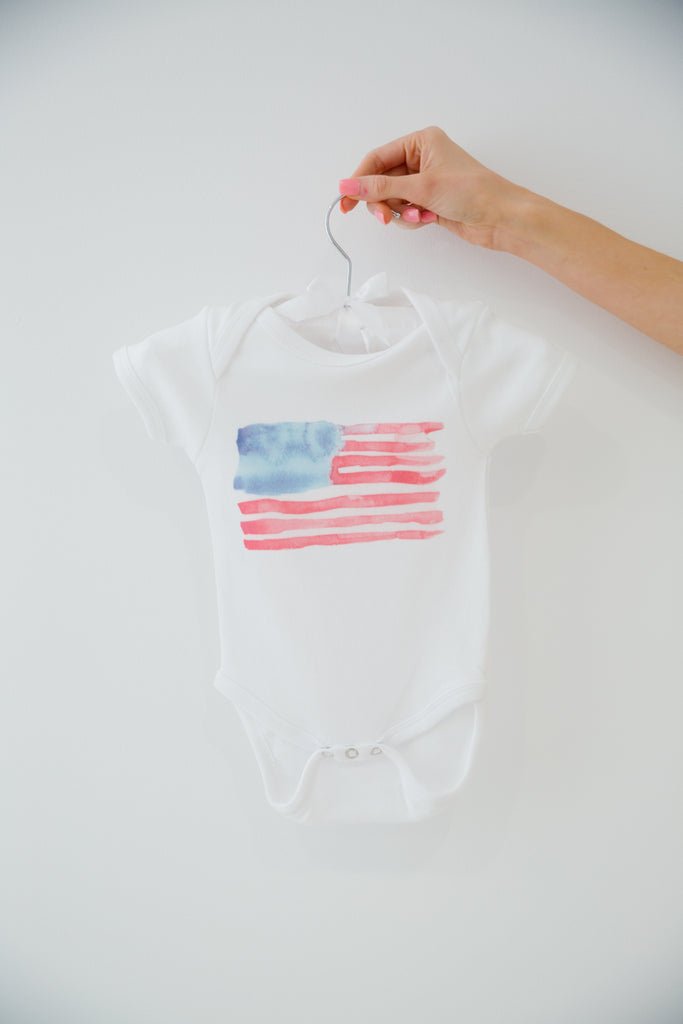 White onesie with a watercolor American flag
