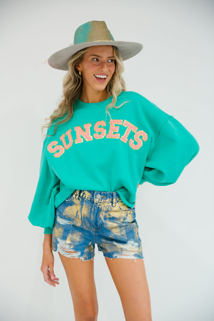 Teal cropped pullover with Sunsets in coral glam letters