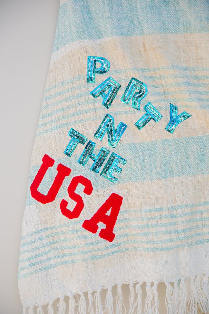 Blue striped towel with blue sequin and red "Party In The USA" letters