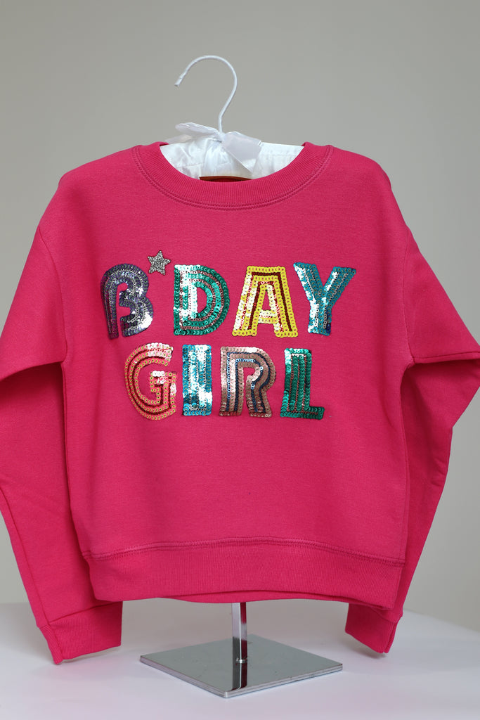 Pink pullover with "bday girl" in colorful sequin lettering and a silver rhinestone heart. 