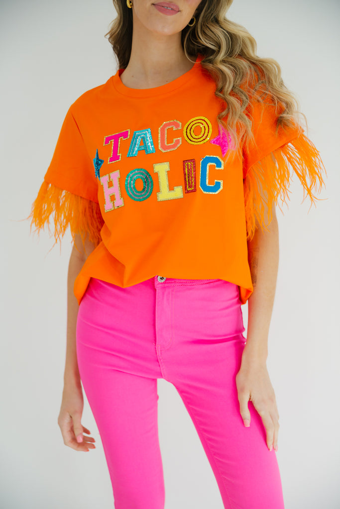 Orange feather tee with Tacoholic in sequin and rainbow terry letters