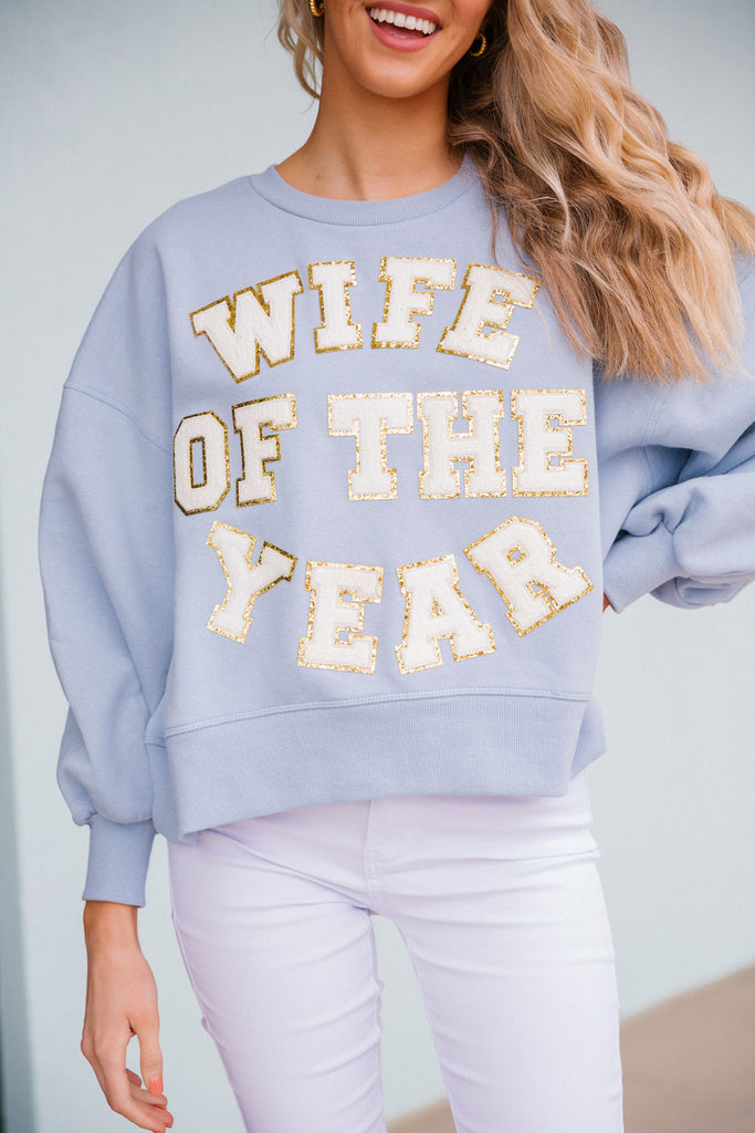 Light blue cropped pullover with white glam "wife of the year" letters